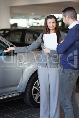 Woman showing a car to a client
