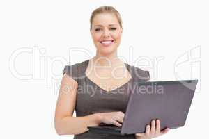 Woman smiling while using a laptop
