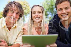Portrait of three students using a tactile tablet
