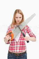 Woman holding a saw and a hammer