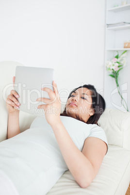 Woman lying on a sofa while reading a paper