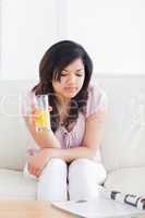 Woman sitting on a sofa while holding a glass of juice