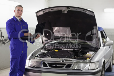 Mechanic typing on a computer while looking at camera