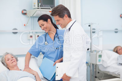Nurse and doctor next to a patient