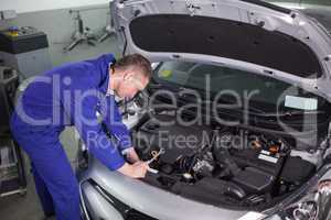 Concentrated mechanic repairing a car