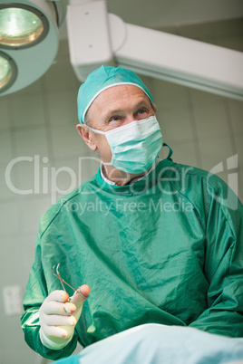 Smiling surgeon holding scissors