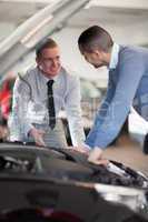 Two men looking at a car engine