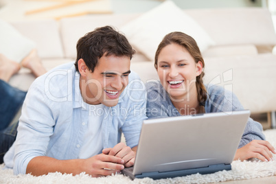 Young Couple lying while using a computer