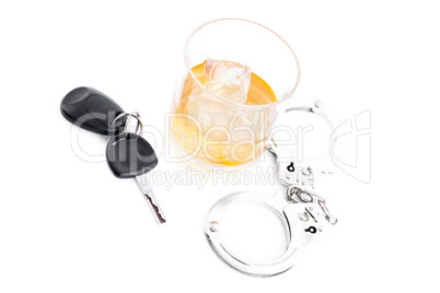 Tumbler glass with whiskey with car key and handcuff