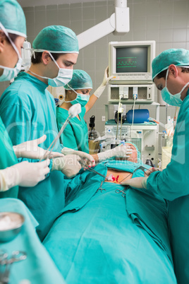 Side view of a surgical team next to a patient