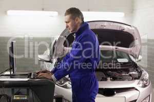 Concentrated mechanic looking at a computer