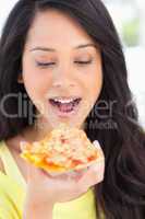 Close up of a woman looking at the slice of pizza she is about t