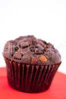 Dark chocolate muffin on a red table