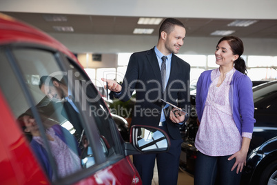 Salesman showing a car to a woman