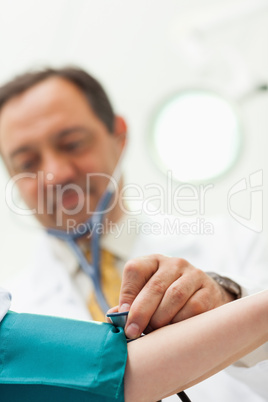 Doctor placing his stethoscope on the arm of his patient