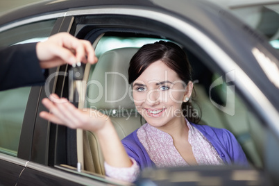 Smiling woman smiles as she sits in a car