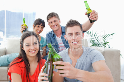 A group of friends celebrating by clinking bottles together