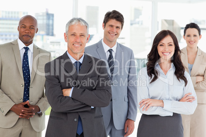 Smiling business team standing in front of a bright window