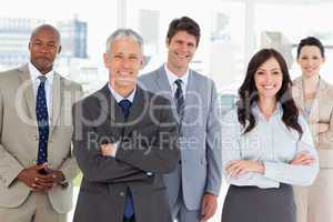 Smiling business team standing in front of a bright window