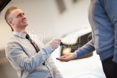 Smiling man giving keys to a man
