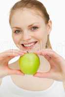 Blonde-haired girl smiling while presenting an apple