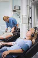 Female patient listening music while being transfused