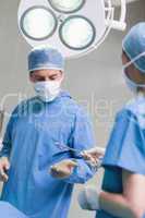 Nurse giving surgical scissors to a doctor