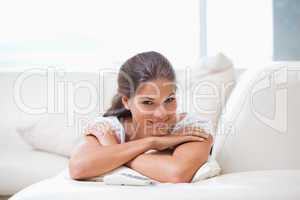 Woman smiling while lying on a sofa