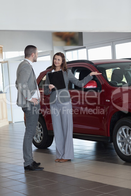 Businesswoman showing a car