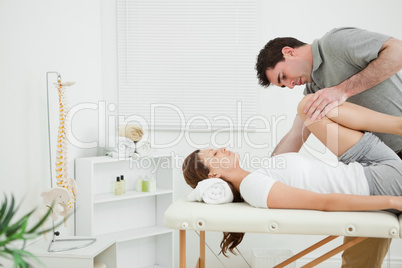 Brunette woman being stretched while she is lying