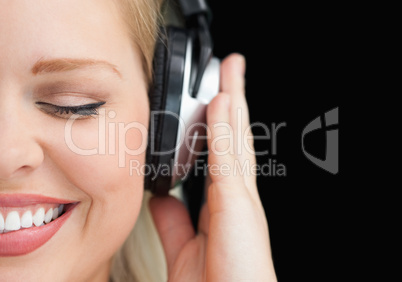 Joyful woman closing her eyes while listening to music