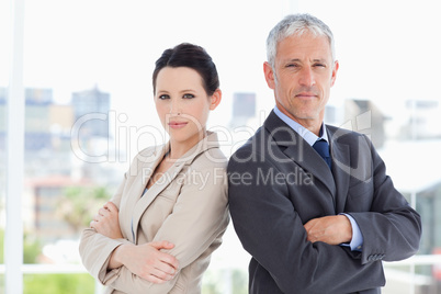 Business people standing upright in front of the window side by