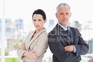 Business people standing upright in front of the window side by