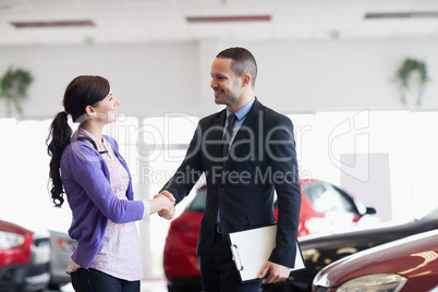 Smiling salesman shaking the hand of a woman