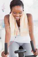 Black woman on a bike listening music while smiling