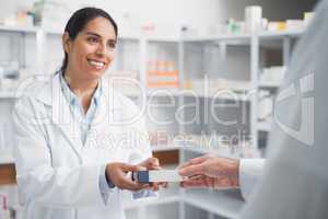 Smiling pharmacist giving a box to a doctor