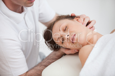 Woman being massaging by the doctor while having the head turn i