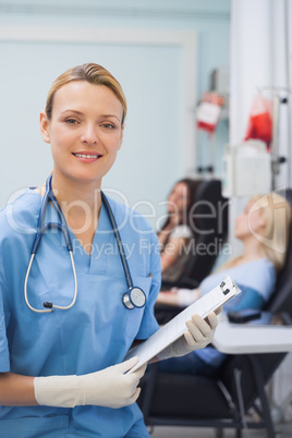 Nurse looking at camera while holding a clipboard