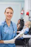 Nurse looking at camera while holding a clipboard