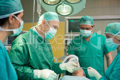 Smiling surgeon working with a team