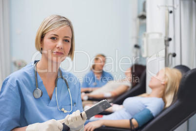 Nurse holding a clipboard next to a transfused patient