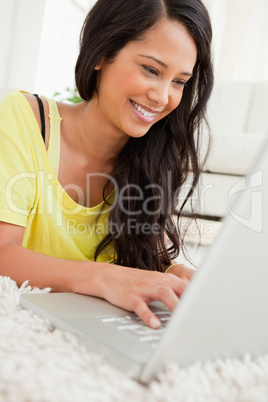 Close-up of a beaming Latin chatting on a laptop