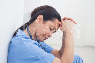 Upset nurse sitting on the floor