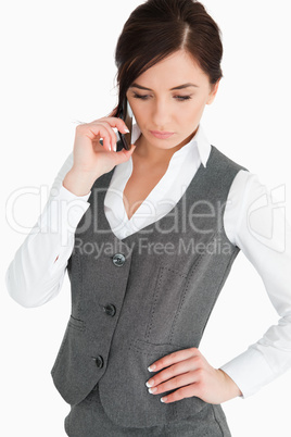 Attractive woman in suit looking down while phoning