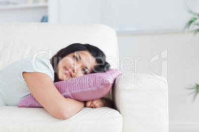 Woman relaxing on a sofa while holding a pillow