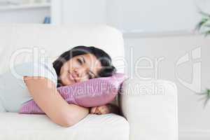 Woman relaxing on a sofa while holding a pillow