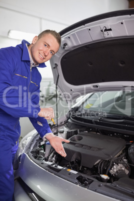 Smiling mechanic showing an engine