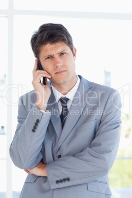 Serious businessman making a call while looking at the camera