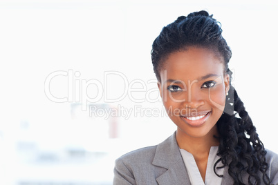 Young employee standing upright in front of a bright window whil