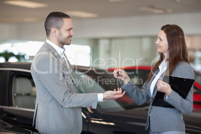 Woman giving car keys to a client